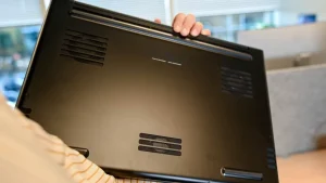 شخصی که یک لپ تاپ وارونه در دست دارد.