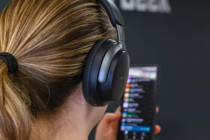 شخصی که با استفاده از یک جفت هدفون Bose QuietComfort Ultra به موسیقی گوش می دهد.