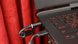 شارژری که به لپ‌تاپ نزدیک پرده وصل شده است.