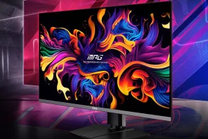 MSI MPG321URX روی میز با پس زمینه چند رنگ.