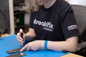شخصی در فروشگاه uBreakiFix در حال تعمیر تلفن.