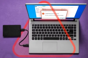 لپ تاپ متصل به درایو خارجی با پیام خطا روی صفحه.