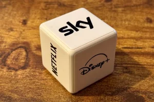 یک کنترلر مکعب Aqara با برچسب هایی برای Sky، Netflix، و Disney+.