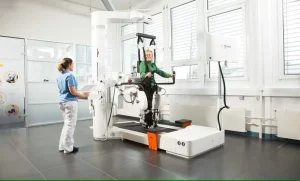 یک سیستم رباتیک متصل به بدن بیمار، روی تردمیل با مهاربند، که برای آموزش توانبخشی راه رفتن استفاده می شود.
هوکوما