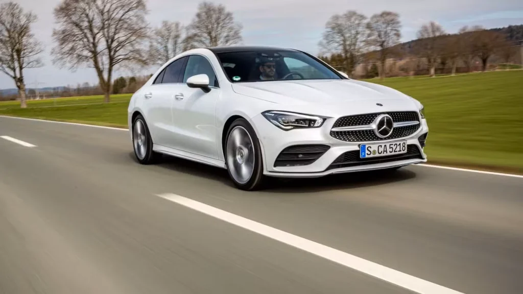 عکس 3/4 جلوی مرسدس بنز CLA سفید 2019 در حال رانندگی در جاده ای روستایی.
مرسدس بنز