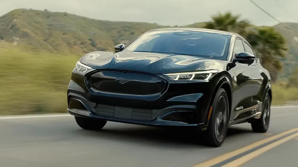 جلوی دینامیک ۳/۴ شات یک موستانگ مک-ای پریمیوم مشکی ۲۰۲۳ در حال رانندگی در جاده‌ای روستایی.

فورد