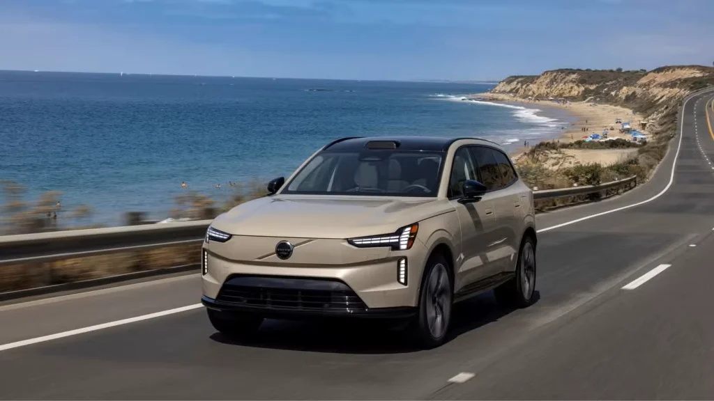 نمای 3/4 جلوی یک ولوو EX90 به رنگ شن و ماسه که در جاده‌ای کنار اقیانوس در حال رانندگی است.

ولوو