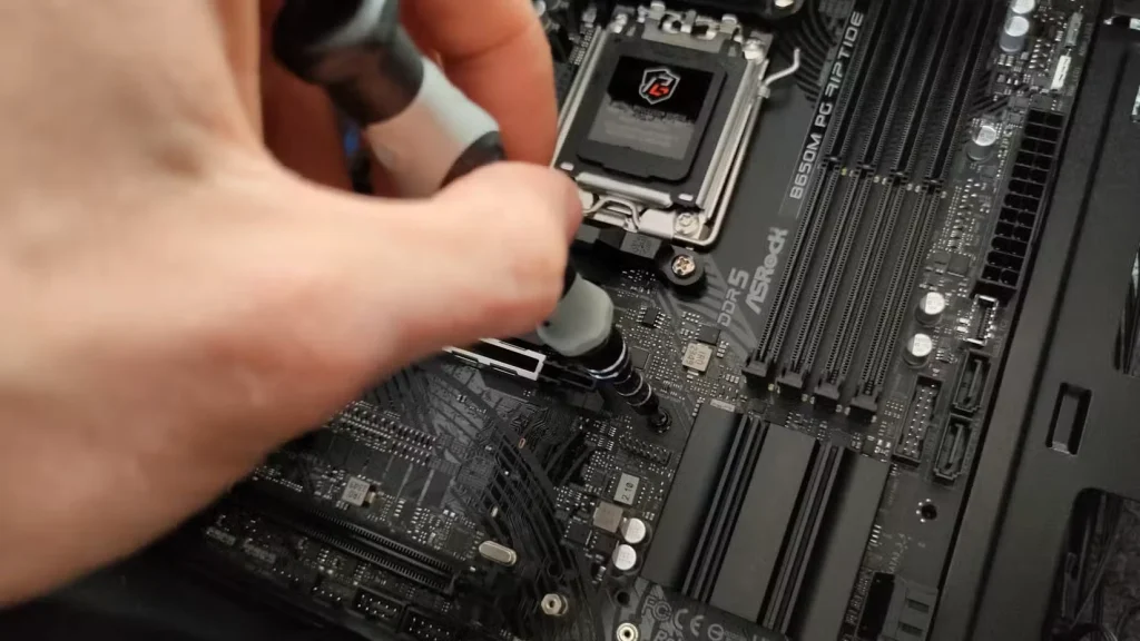 دستی که یک مادربرد را به کیس کامپیوتر میپیچد.